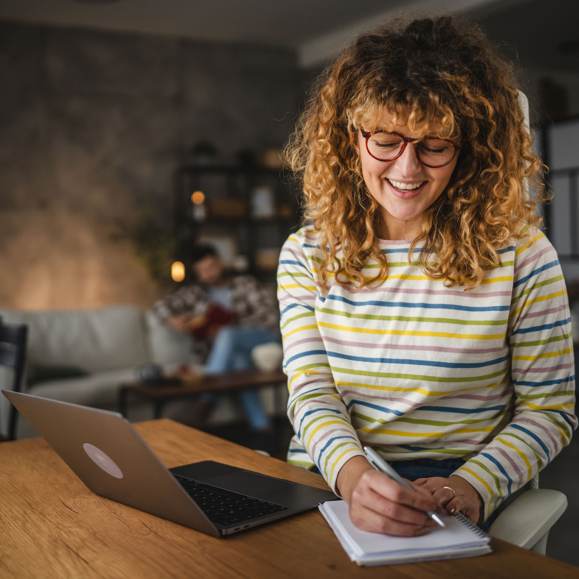 mom work from home take a notes in a notebook from laptop